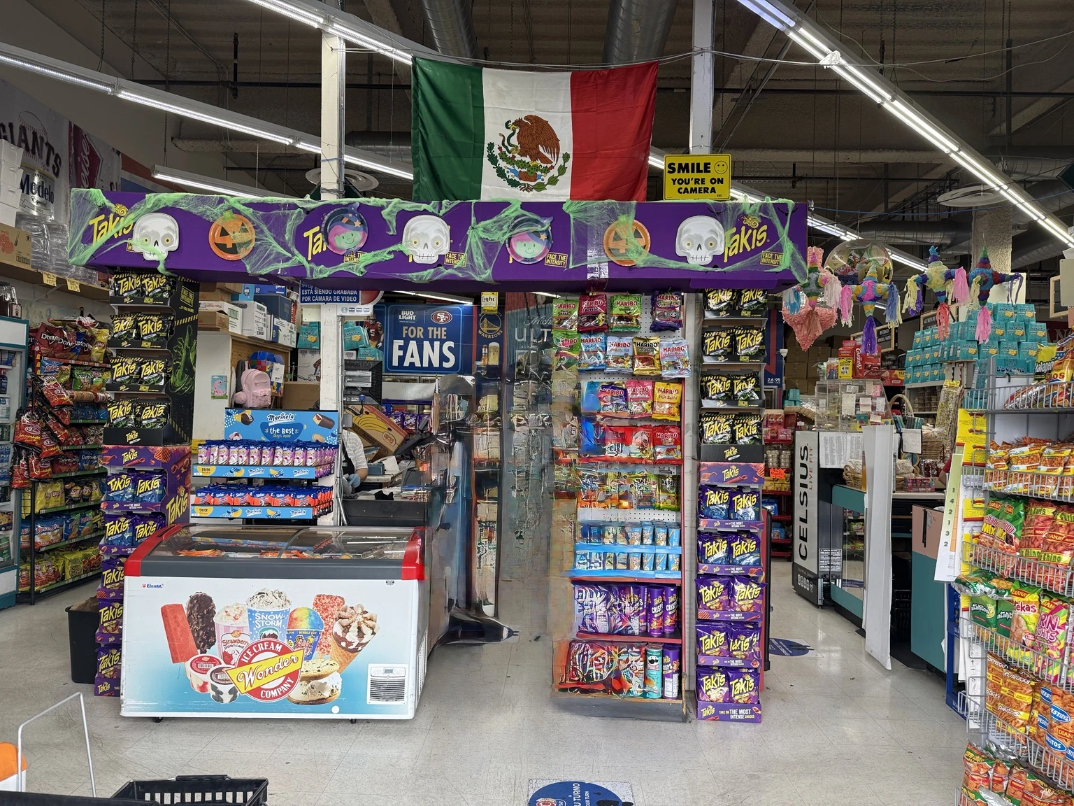 Inside Daly City Market with Mexican groceries, snacks, frozen treats, and colorful piñatas